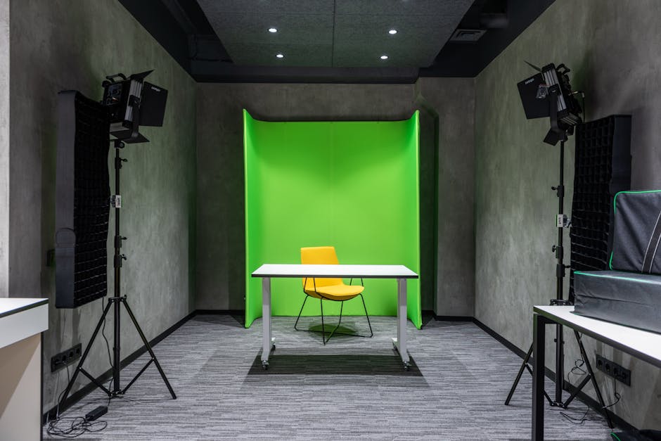 Comfortable yellow chair at white table placed near green wall in spacious modern studio with contemporary lighting equipment and professional supply